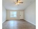 Bright living room with hardwood floors, ceiling fan, and a large window offering ample natural light at 8051 Trinity Park Dr, Riverdale, GA 30296