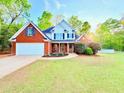 Lovely brick home featuring a manicured lawn, white garage door, and a welcoming front porch at 515 Sherwin Ct, Mcdonough, GA 30252
