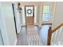 Bright foyer featuring a modern rug, light wood door, and staircase with white rails at 515 Sherwin Ct, Mcdonough, GA 30252