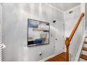 Hallway with hardwood floors, white trim, staircase, and artwork at 833 Charles Bank Se Ave, Atlanta, GA 30312