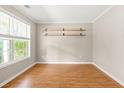 A bright, sunny room with wood floors, neutral walls, and minimalist decor with shelving at 182 Garden Manor Ct, Loganville, GA 30052