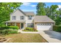 Inviting two-story home with a two-car garage, manicured lawn and complemented by stone accents at 182 Garden Manor Ct, Loganville, GA 30052