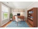 Bright home office with wood floors, built-in shelves, and large window offering ample natural light at 182 Garden Manor Ct, Loganville, GA 30052