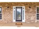 Leaded glass front door with sidelights surrounded by a stone facade and exterior lighting at 3012 Keeneland Blvd, Mcdonough, GA 30252