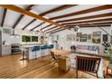 Open-concept living room flows into the kitchen with wood floors and beamed ceilings at 1619 Folkstone Ne Rd, Brookhaven, GA 30329