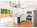 Modern kitchen with white cabinets, stainless steel appliances, and sliding doors to backyard at 3022 Kentmere Dr, Cumming, GA 30040