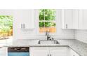Bright kitchen featuring granite countertops, stainless steel sink, and white subway tile backsplash at 3022 Kentmere Dr, Cumming, GA 30040