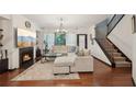 Bright living room features a fireplace, modern lighting, plush seating, and stairs to the upper level at 4430 Cedar Bridge Walk, Suwanee, GA 30024