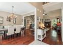 Open-concept dining room featuring hardwood floors, a chandelier, and seamless flow to the living room at 545 Creek Landing Ln, Alpharetta, GA 30005