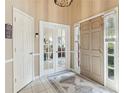 Inviting foyer with neutral tones, decorative rug, and sidelight windows flanking the front door at 545 Creek Landing Ln, Alpharetta, GA 30005