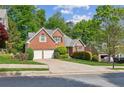 Lovely brick home with a well-maintained lawn, mature trees, and a spacious driveway at 545 Creek Landing Ln, Alpharetta, GA 30005