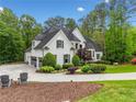 Charming home with a side entry garage, lush landscaping, and a circular driveway at 560 Indigo Dr, Roswell, GA 30075