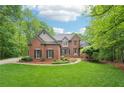 Charming two-story brick home featuring lush landscaping, manicured lawn, and inviting front entrance at 1275 Smokehouse Trl, Cumming, GA 30041