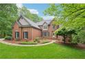 Attractive two-story brick home with a well-maintained yard, stone walkway, and beautiful mature tree at 1275 Smokehouse Trl, Cumming, GA 30041