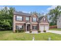 Inviting two-story home featuring a brick facade, two-car garage, and manicured front lawn at 3225 Rex Ridge Dr, Rex, GA 30273