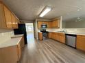 Functional kitchen with stainless steel appliances, wooden cabinets and vinyl flooring at 1822 Millwood Park Ct, Buford, GA 30518