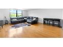 Open living area with hardwood flooring, a large sectional sofa, and views of trees outside window at 2965 Pharr Court South Nw # 1-817, Atlanta, GA 30305