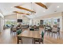 Open concept clubhouse interior with wood beams, elegant lighting, fireplace, dining tables, and a kitchen at 3472 Fishpond Cir, Dacula, GA 30019
