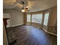 Bright living room featuring hardwood floors, a stone fireplace, and large bay windows at 71 Streamview Trl, Douglasville, GA 30134