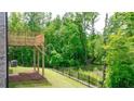 Outdoor wooden deck overlooks a backyard featuring a black iron fence and lush greenery at 1416 Clear Pond Lane, Dacula, GA 30019