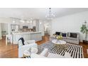 Open concept living space with a view into the kitchen, hardwood floors, and stylish furniture at 150 Park Creek Dr, Alpharetta, GA 30005