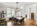 Elegant dining room with hardwood floors, wainscoting, and a modern chandelier at 6330 Beaver Crossing Dr, Cumming, GA 30040