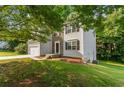 Two-story home with stone accents, two-car garage, and lush green lawn for an inviting curb appeal at 110 Slate Ridge Ln, Loganville, GA 30052