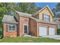 Inviting brick home with attached two-car garage, front yard and classic architectural details at 3812 Maclaren Dr, Clarkston, GA 30021