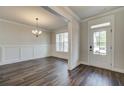 Bright dining room with dark hardwood floors, wainscoting detail, and modern chandelier at 3890 Ivy Cottage Dr, Snellville, GA 30039