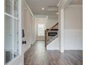 Welcoming foyer showcasing hardwood floors leading to staircase with iron spindles and white trim at 3890 Ivy Cottage Dr, Snellville, GA 30039