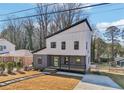 A modern two-story home stands on a manicured lawn, boasting large windows and a stylish design at 665 Ferris St, Atlanta, GA 30310