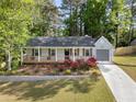 Inviting single-Gathering home showcasing a lovely front porch and a green lawn adorned with vibrant rose bushes at 874 Fox Valley Dr, Stone Mountain, GA 30088