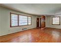 Spacious living room with large windows, hardwood floors, and a decorative divider, creating a warm and inviting ambiance at 1815 Windsor Sw Dr, Atlanta, GA 30311
