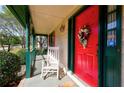 Close-up of the inviting front porch with a rocking chair and festive red door at 3740 Laurel Brook Way, Snellville, GA 30039