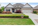 Charming one-story brick home with a well-manicured lawn and blue shutters offers a welcoming curb appeal at 4815 Amble Trce, Cumming, GA 30040