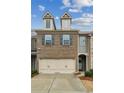 Attractive townhome showcasing a two-car garage, brick facade, and well-maintained front yard at 6595 Story Cir, Norcross, GA 30093