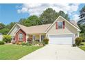 Charming home with a well-maintained lawn and colorful flowerbeds and a two car garage at 20 Queensland Ln, Covington, GA 30016