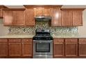Updated kitchen with stainless steel gas range, granite counters, and custom cabinets at 548 Myrtle Trace Ln, Suwanee, GA 30024