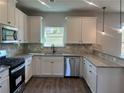 Well-equipped kitchen features white cabinets, stainless steel appliances, and granite countertops at 4140 Chapel Hill Reserve, Douglasville, GA 30135