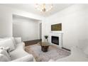 Bright living room featuring a decorative chandelier, fireplace, and hardwood floors at 1961 Vidalia Ct, Dacula, GA 30019
