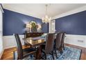 Elegant dining room featuring a chandelier, blue walls, and hardwood floors at 7545 Brookwood Way, Cumming, GA 30041