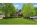 Inviting home with a verdant lawn, mature trees, and traditional architectural details at 2551 Raintree Ne Dr, Atlanta, GA 30345