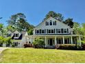 Beautiful white two-story home with black shutters and a welcoming porch in a lush green lawn setting at 10192 Shallowford Rd, Roswell, GA 30075