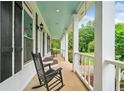 Relax on this covered porch with rocking chairs and a cool blue ceiling perfect for enjoying the outdoors at 10192 Shallowford Rd, Roswell, GA 30075