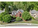 Beautiful aerial view of a brick home surrounded by lush greenery and manicured lawns at 3284 Bakers Mill Ct, Dacula, GA 30019