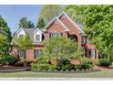 Charming brick home with black shutters, manicured landscaping, and mature trees at 3284 Bakers Mill Ct, Dacula, GA 30019