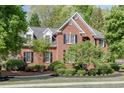 Stunning red brick home with black shutters, complemented by verdant landscaping and a well-manicured lawn at 3284 Bakers Mill Ct, Dacula, GA 30019
