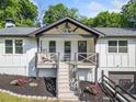 Inviting front porch with rocking chairs on this charming white home with black trim and a 2-car garage at 369 Arnold Mill Rd, Woodstock, GA 30188