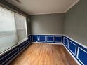 Empty room featuring wood floors, blue trim, and bright window at 4341 Savannah Ln, Atlanta, GA 30349