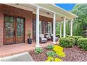 Inviting front porch with chairs, columns, and well-maintained landscaping at 4592 Planters Hill Dr, Powder Springs, GA 30127